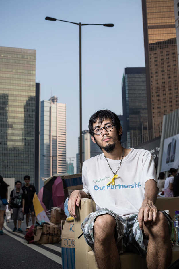 Pro-democracy protester poses on appropriated furniture in Central, Hong Kong