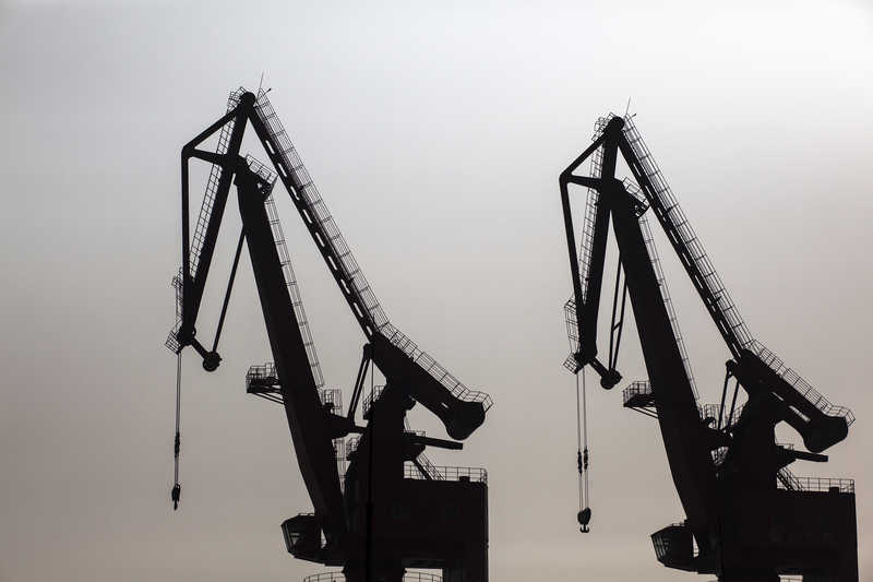 Cranes stand idle at the Port of Shekou in Shenzhen