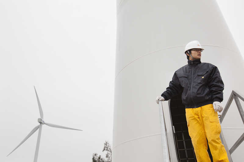 A China Resources New Energy Group employee stands at a wind turbine in Shantou