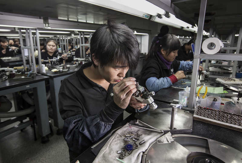 Workers polish diamonds at Guangzhou Mickey Weinstock & Co factory