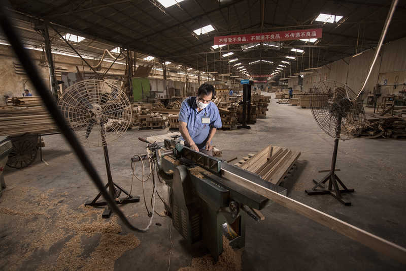 A worker operates a planer at a factory in Panyu