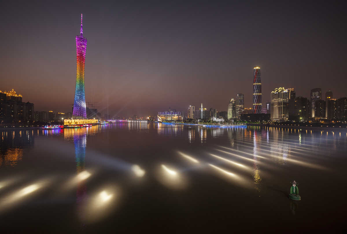 Photograph of the Guangzhou Tower, IFC Tower and other Tianhe District buildings flanking the Pearl River at dusk.